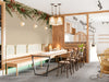 A restaurant wall featuring a winter pine and holly garland mural above a farmhouse wooden table.