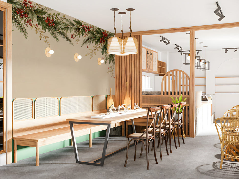 A restaurant wall featuring a winter pine and holly garland mural above a farmhouse wooden table.