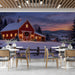 A cafe wall featuring a peaceful winter barn landscape with warm glowing windows.