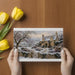 Snowy cottage scene wallpaper used as an accent in a quiet reading nook