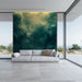 Modern living room with a gray sofa and a large wall mural of green foliage.