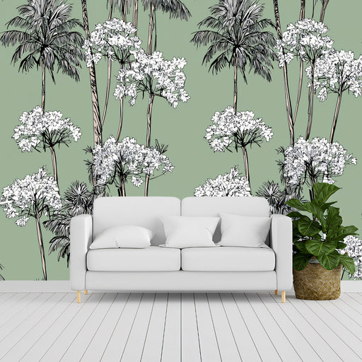 White sofa in a room with a green wall featuring palm tree and white flower pattern.