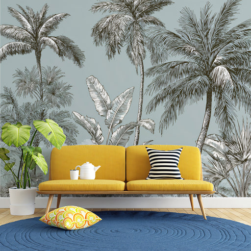 Yellow sofa with decorative pillows in a room with palm tree wallpaper.