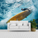 White sofa in a room with a large wall mural of a surfer on a wave.