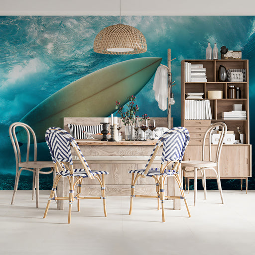 Dining area with surfboard against a blue wall, featuring striped chairs and a bookshelf.