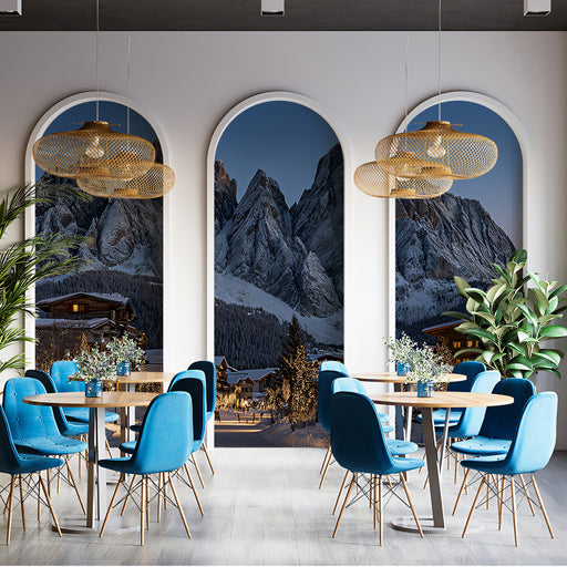 Modern dining area with blue chairs and wooden tables, featuring a mountain landscape in the background.